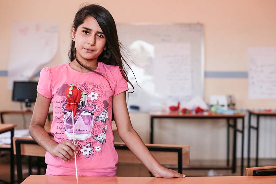A child holds a puppet she made during summer school in Lebanon