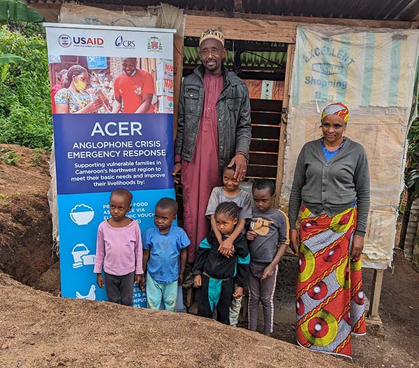 Cameroon family standing near sign