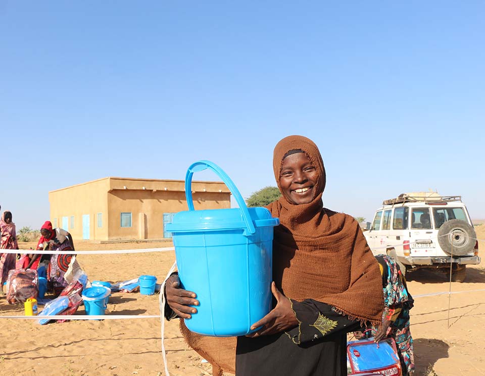 Sudanese refugee holding bucket