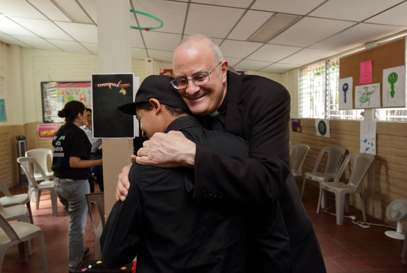 Bishop Gregory John Mansour of Brooklyn, New York, embraces Manuel,* a former gang member, during a recent visit to El Salvador. Photo by Silverlight for CRS