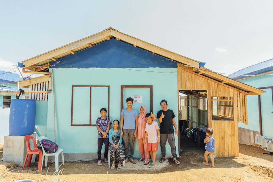 Filipino family outside new shelter