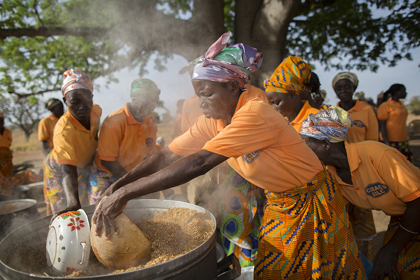 Women in Ghana process rice to capture more of the value of their crop. Photo by Jake Lyell for CRS