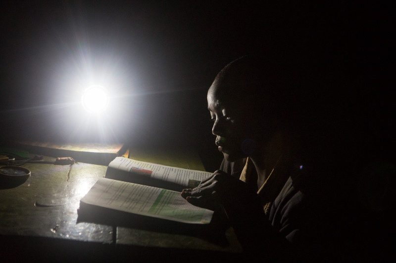 Levis studies by the light of a solar lamp late into the night. Felix saved his money to give his brother this luxury and help him succeed in school. Photo by Sara A. Fajardo/CRS