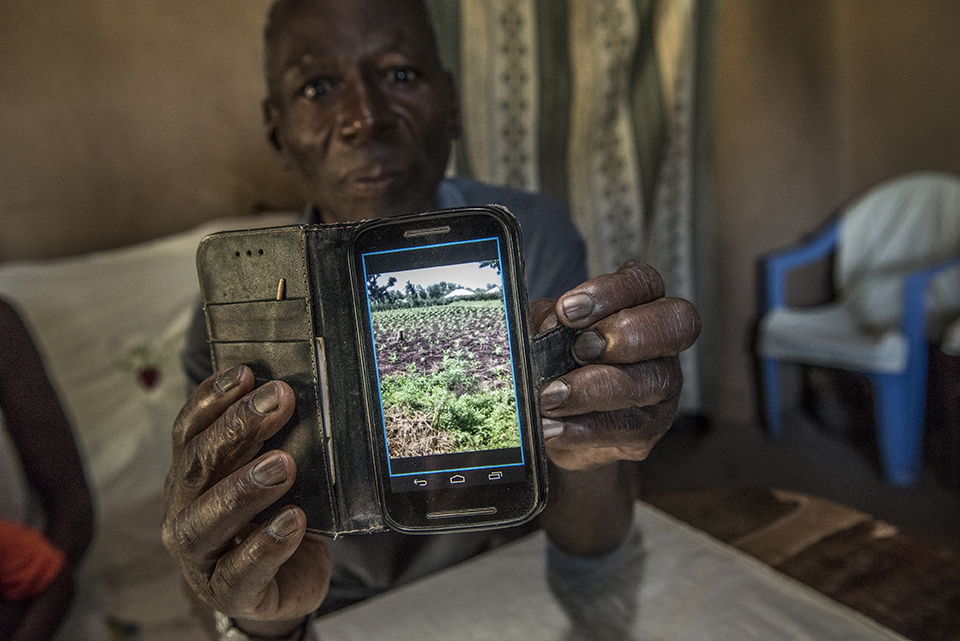 Kenya farmer shows picture of land