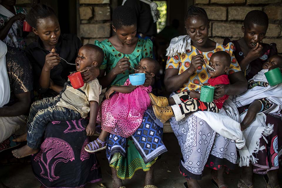 parents feed children in Tanzania nutrition workshop