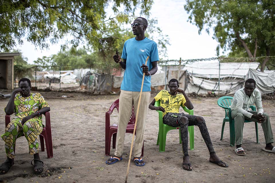 South Sudanese man speaking to a group of men
