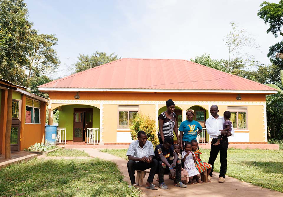 Uganda vanilla grower and family outside their home