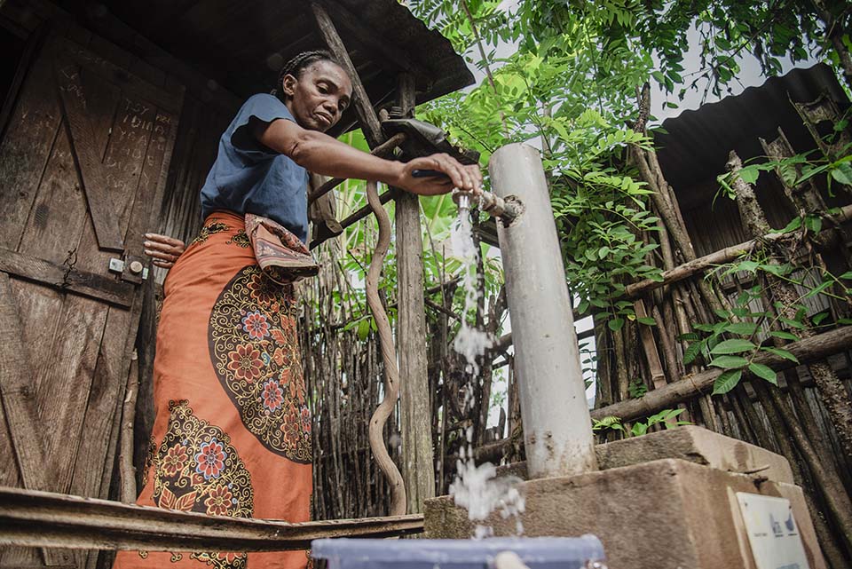woman at a water tap in Madagascar 