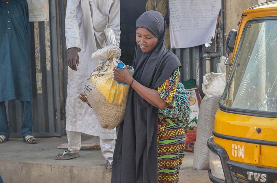woman carries bag of food in Nigeria 