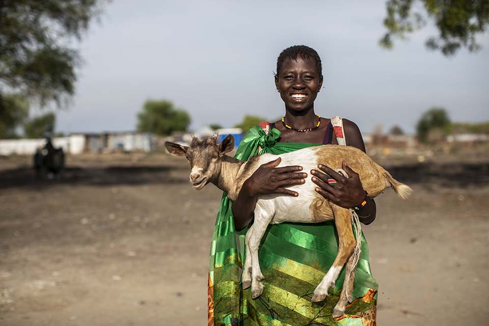 woman holds a goat at a livestock fair in South Sudan