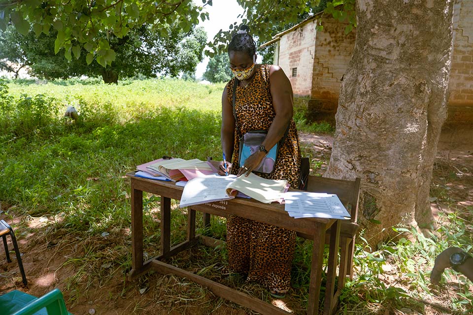 woman stands at a table at a school in Guinea Bissau