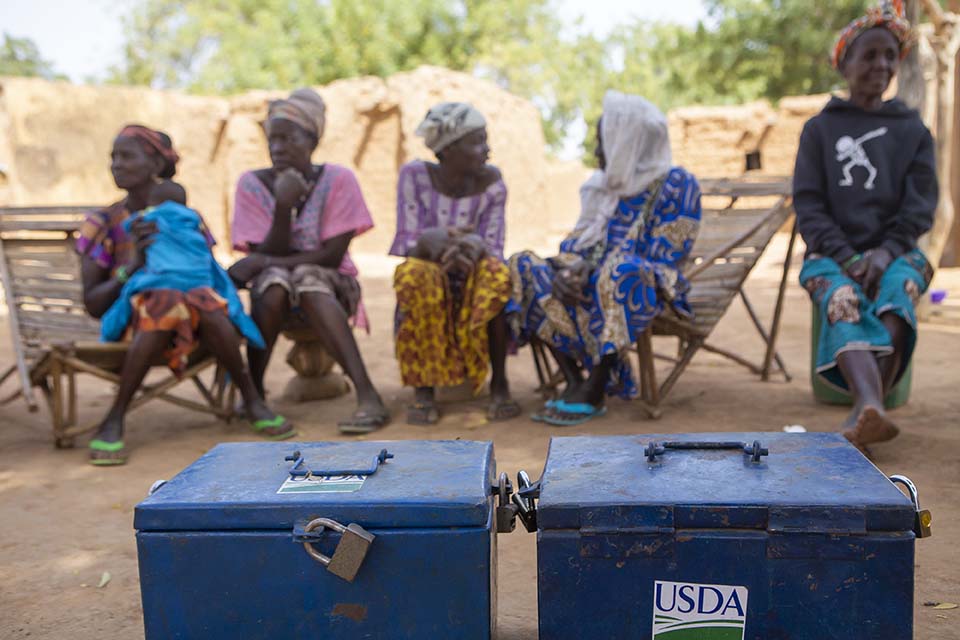 women gather around a cash box in Mali