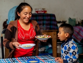 Woman serves food to her young son  