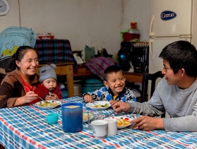 Woman eats at the table with her husband and two children  