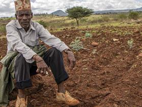 Man from Kenya sits in a field