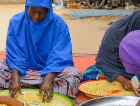 women husking soybeans in Nigeria